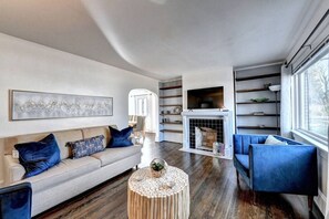Another angle of the beautifully designed living space, complete with a cozy fireplace and smart TV