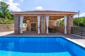 A covered dining area beckons guests to enjoy al fresco meals in style
