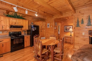 Dining space for four in the kitchen with black appliances at Dreams Do Come True, a 1-bedroom cabin rental located in Pigeon Forge