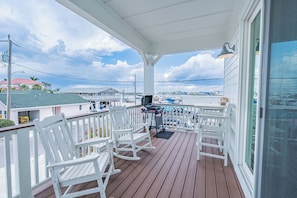 Cozy front porch with seating and a stunning view of the bay — perfect for morning coffee or evening sunsets.