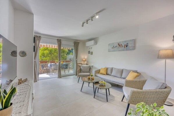 Spacious family living room with a large smart TV and access to a terrace.