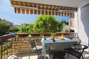 Comfortable south-facing terrace with expandable shade and a dining table.