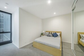 A bedroom with a queen sized bed & plush pillows.