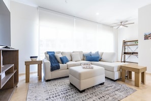 Living room with a large smart TV and a spacious, comfy sofa — perfect for movie nights and relaxing after a day out.