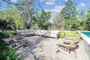 The outdoor seating area features a large sofa and Adirondack chairs, creating a cozy spot to relax and enjoy the fresh air.