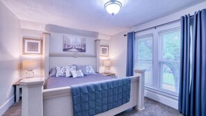 King bed with large windows and draperies