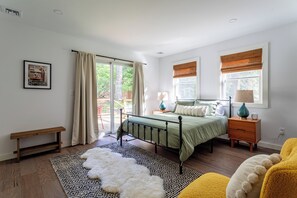 Spacious first-floor bedroom with a queen bed, large windows, and abundant natural light.