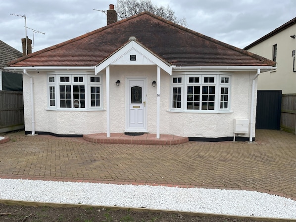Front of the property, with spacious driveway for parking.
