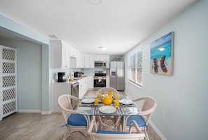 The cozy dining area is nestled between the kitchen and living room and features a stylish table with seating for four.