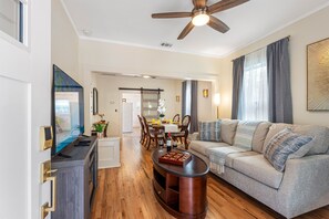 The open-plan design of the living area makes it feel spacious and airy, with natural light streaming in through the windows, adding to the overall inviting feel of the space.