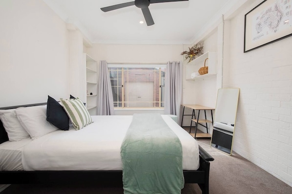 A dedicated workspace tucked beside the bed offers a quiet nook for catching up on emails or planning the day’s adventures, complemented by built-in shelving for thoughtful organisation.