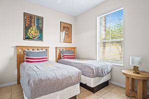 Double twin bedroom with ceiling fan and Harry Potter-themed wall art