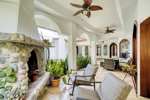 Relax on the wraparound patio in rocking chairs by the fireplace and greenery.