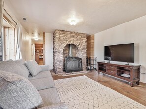 Basement suite with wood burning fireplace, sleeper sofa and 56" Smart TV