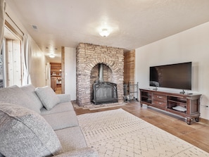 Basement suite with wood burning fireplace, sleeper sofa and 56" Smart TV