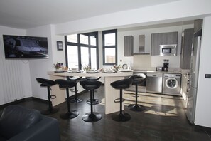 Modern open-plan kitchen with bar seating, ideal for sharing meals or morning coffee with family.