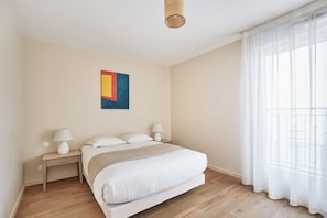 Relax in the cozy living room with soft furnishings and natural light—an ideal space to unwind after exploring Levallois or central Paris.