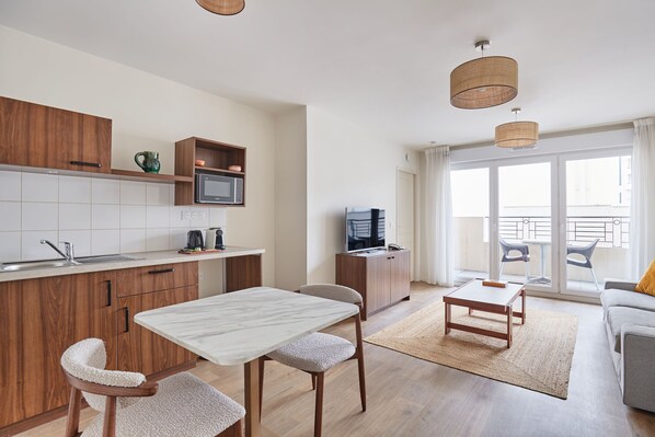 Bright open-plan apartment with a fully equipped kitchenette, perfect for enjoying home-cooked meals just minutes from Paris.