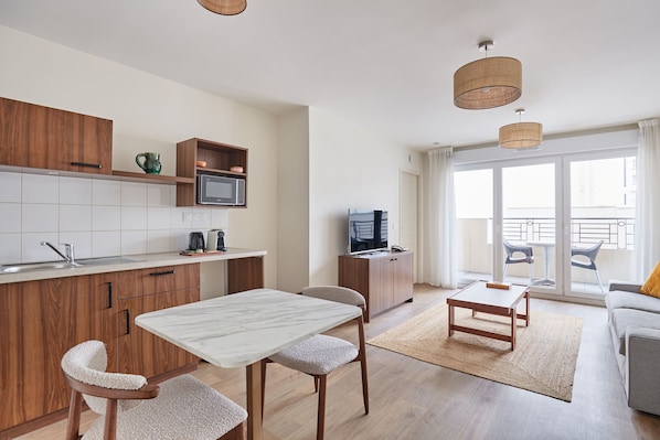 Bright open-plan apartment with a fully equipped kitchenette, perfect for enjoying home-cooked meals just minutes from Paris.