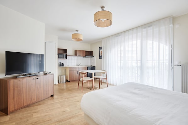 Bright studio with a cozy double bed and flat-screen TV—perfect for couples or solo travelers seeking Parisian comfort.