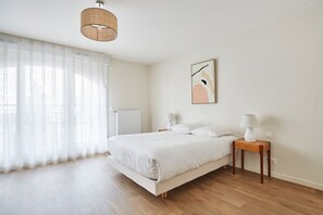 Compact yet inviting sleeping and dining space, framed by large windows and soft lighting.