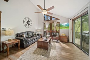 Bright Living Room with Leather Sofa, TV, and Sliding Glass Doors to the Deck