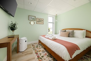 Designed for relaxation, this bedroom offers a bright window for natural light, a comfortable setting for unwinding, and stylish touches that make it a true sanctuary.