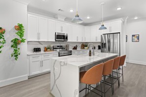 Cook, sip, and connect in this stunning modern kitchen featuring luxe marble countertops, stainless steel appliances, and cozy bar seating perfect for morning coffee or evening cocktails. Whether you're a foodie or just here for the vibes, this space has everything you need to feel right at home.