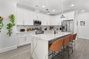Cook, sip, and connect in this stunning modern kitchen featuring luxe marble countertops, stainless steel appliances, and cozy bar seating perfect for morning coffee or evening cocktails. Whether you're a foodie or just here for the vibes, this space has everything you need to feel right at home.