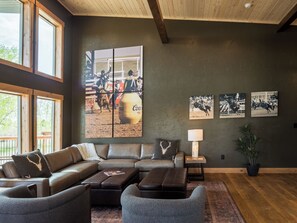 Designed for connection and comfort, the vaulted great room invites your group to gather around for meals, movies, or a late-night chat. Two ottomans discreetly convert into twin beds, offering flexible sleeping space without compromising on style.