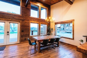 Gather Around with a View of Carter Mountain
This handcrafted dining table sits beneath soaring ceilings and south-facing windows that frame one of Cody’s most iconic backdrops—Carter Mountain. It’s the perfect setting for morning coffee, family feasts, or lingering sunsets over Rattlesnake Mountain and the Shoshone Canyon.