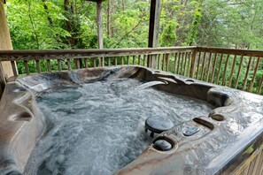 Soak your cares away in the bubbling hot tub while taking in the peaceful forest views—your private mountain retreat awaits just steps from the cabin.