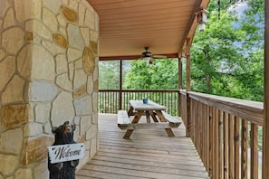 Enjoy casual meals and late-night games at the picnic table on the covered porch—just one of the many charming places to gather at Mama Bear Cabin.