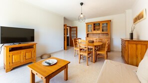 A bright and inviting living area with classic wooden furniture, a cozy sofa, and a large flat-screen TV is ideal for unwinding after a day exploring the city.
#SpaciousLiving #DiningArea #HomeComforts #CozyVibes #LovelyStayPortugal #GatherTogether