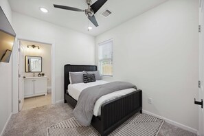 1st-floor bedroom w/ full bed, ensuite bath, & Smart TV for streaming apps.