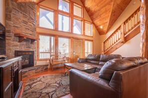 Unwind in the cozy living room, where natural light floods the space, and a stone fireplace beckons for evenings of relaxation and entertainment.