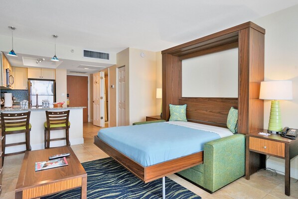 Bedroom Area: Stylish murphy bed setup with colorful accents and a small seating area.