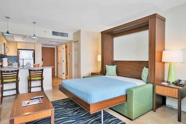 Bedroom Area: Stylish murphy bed setup with colorful accents and a small seating area.