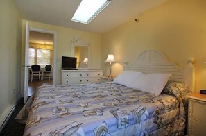 Relax in this spacious king bedroom featuring soft lighting, a sleek modern bed, and cozy ambiance.