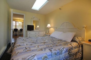 Relax in this spacious king bedroom featuring soft lighting, a sleek modern bed, and cozy ambiance.