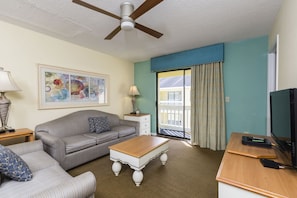 Bright and airy living room with sliding doors that lead to a private balcony, perfect for savoring warm coastal breezes.