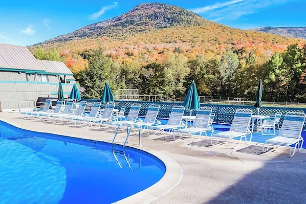 Enjoy breathtaking mountain views from the expansive outdoor pool area, complete with comfortable lounge chairs by the water’s edge.