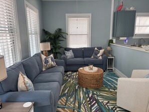 Living room with seating for 6 and additional pillows/blankets in coffee table