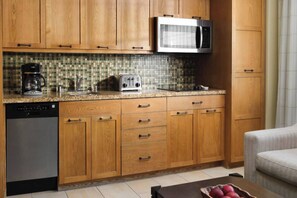 The well-equipped kitchenette features a stove top, dishwasher, Mini-fridge, microwave, toaster, and sink.