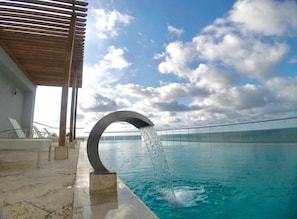 Sunset at the rooftop infinite pool overlooking the beach and ocean.