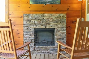 Enjoy cozy evenings by the fireplace on the covered porch with outdoor TV.