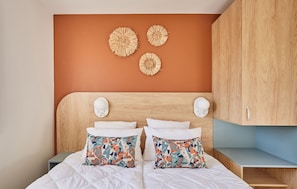 The tranquil bedroom showcases stylish decor with warm tones and plush bedding, creating a restful retreat just minutes from the beach.