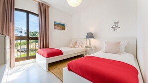 Bright twin bedroom with two single beds, soft linens, and natural light from large windows. Perfect for friends or family stays. #TwinRoom #BrightSpace #ComfortableStay #TravelWithFriends