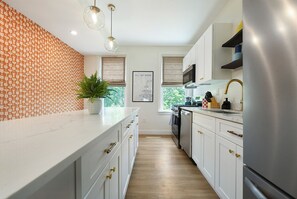 Sleek meets striking—our newly renovated kitchen blends modern design with bold pops of orange and blue for a space that cooks as good as it looks