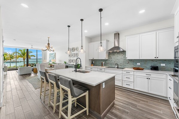 Modern kitchen with sleek white cabinetry, stainless steel appliances, and a spacious island.